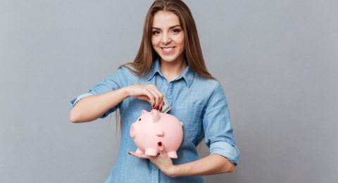 Woman putting money in piggy bank